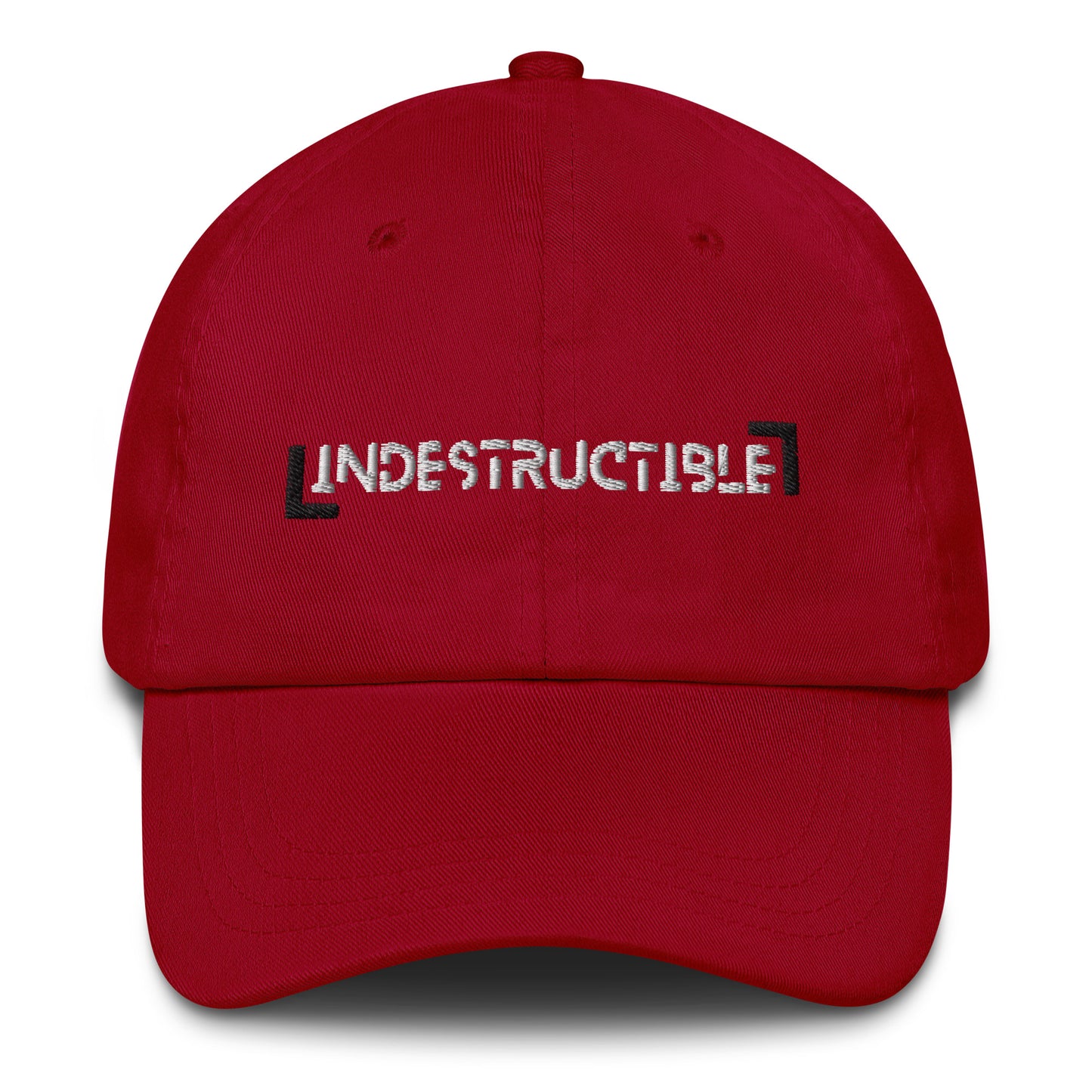Cranberry red baseball cap with embroidered text 'Indestructible.'