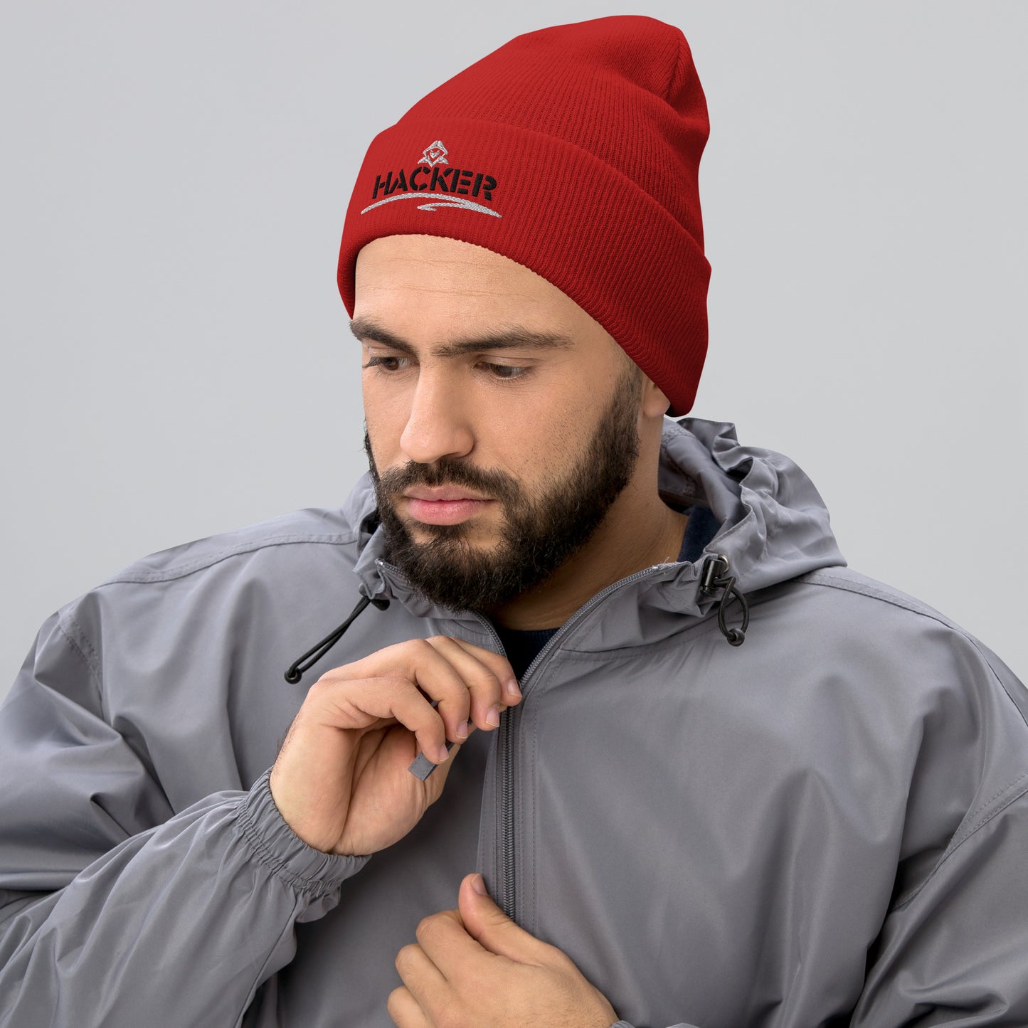 Man wearing a red beanie with the word 'HACKER' embroidered in bold black letters on the front.