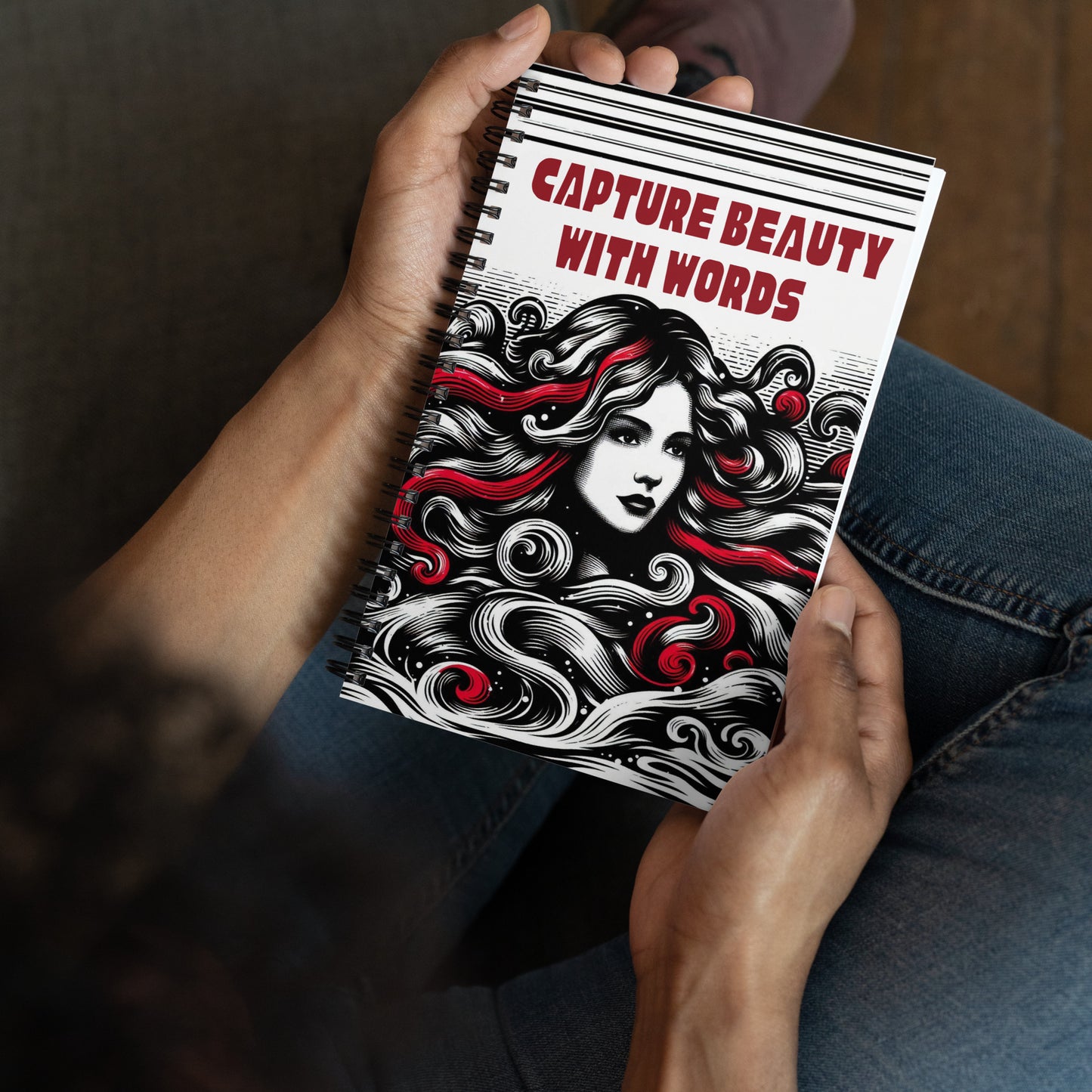 Spiral notepad with text 'Capture Beauty With Words' on the front, and 'The Beauty Within You' on the back. A face of a beautiful woman with black, white and red locks of hair is sketched on the front.
