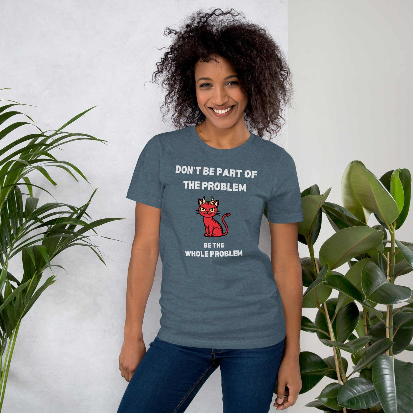 Woman wearing a slate heather unisex t-shirt featuring "DON'T BE PART OF THE PROBLEM, BE THE WHOLE PROBLEM" with a mischievous red devil cat design. Bold, rebellious, and perfect for those who love playful, edgy fashion.