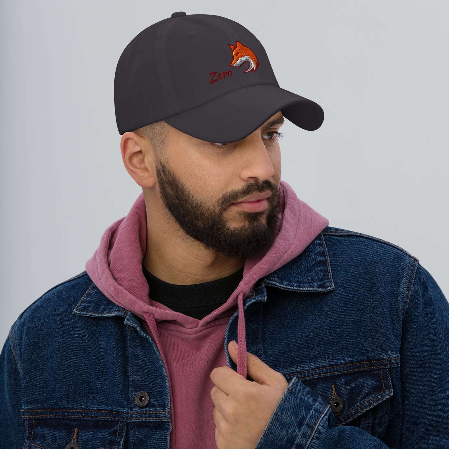 Man wearing dark grey baseball cap with embroidered fox and the word "Zero" on the front, suggesting the phrase "Zero Fox" or "Zero Fcks."