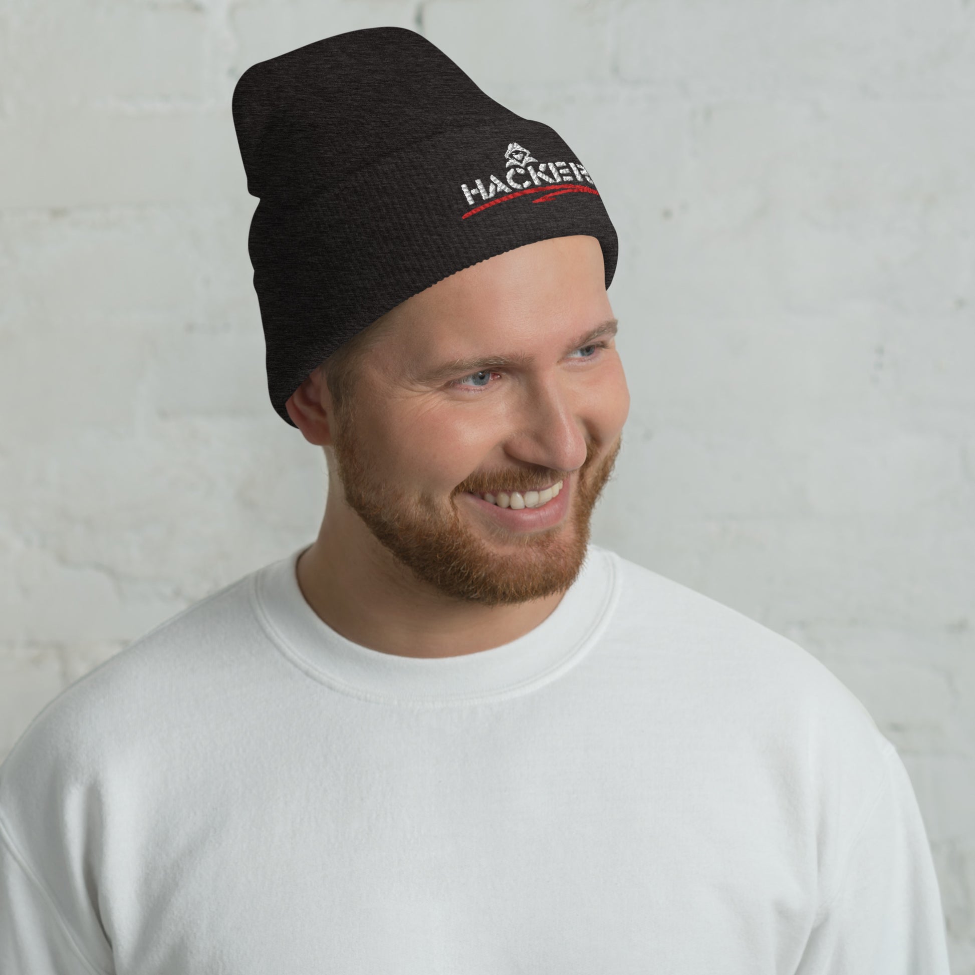 Man wearing a dark grey beanie with the word 'HACKER' embroidered in bold white letters on the front.