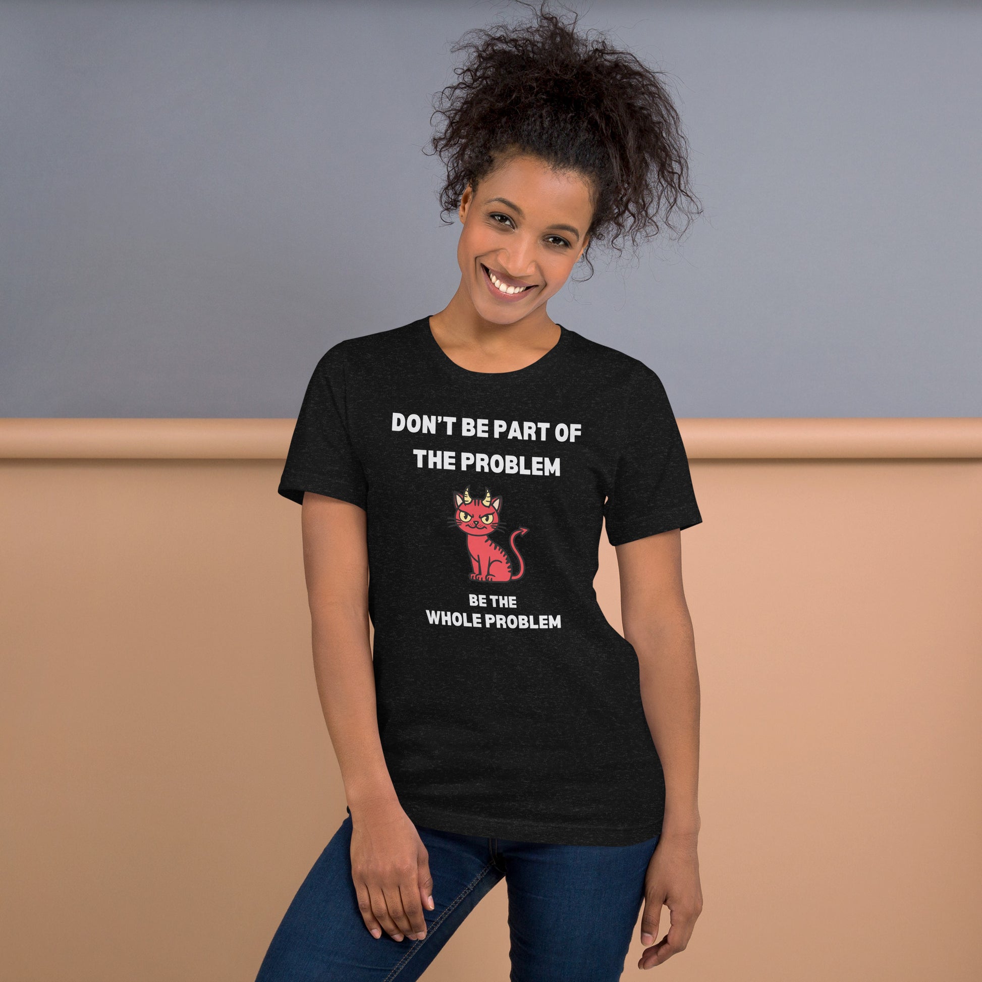 Woman wearing a black heather unisex t-shirt with "DON'T BE PART OF THE PROBLEM, BE THE WHOLE PROBLEM" text and a mischievous red devil cat design. Bold, rebellious, and perfect for those who love playful, edgy fashion.