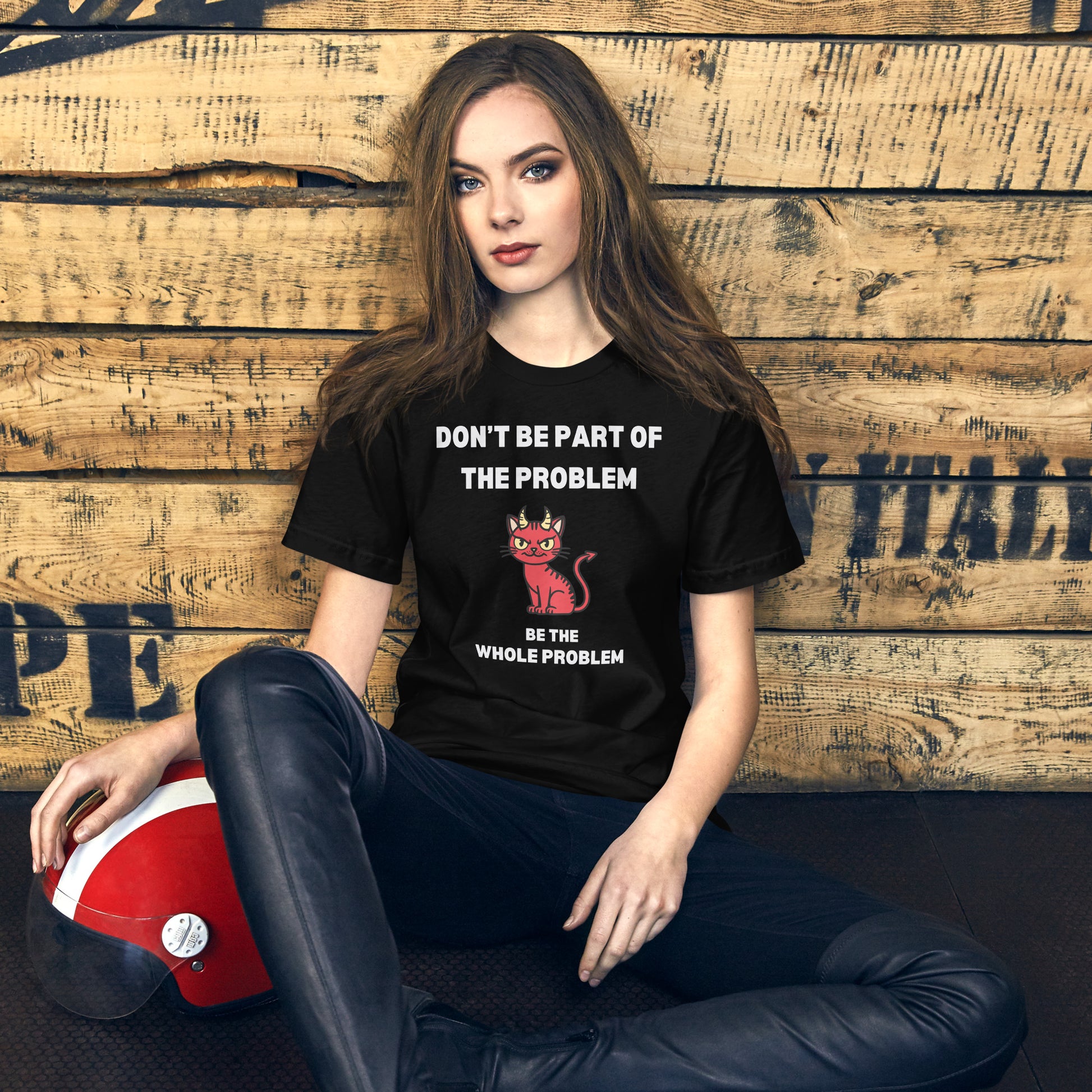 Woman wearing a black unisex t-shirt with text "DON'T BE PART OF THE PROBLEM, BE THE WHOLE PROBLEM" and a mischievous red devil cat design. Bold, rebellious, and perfect for those who love playful, edgy fashion.