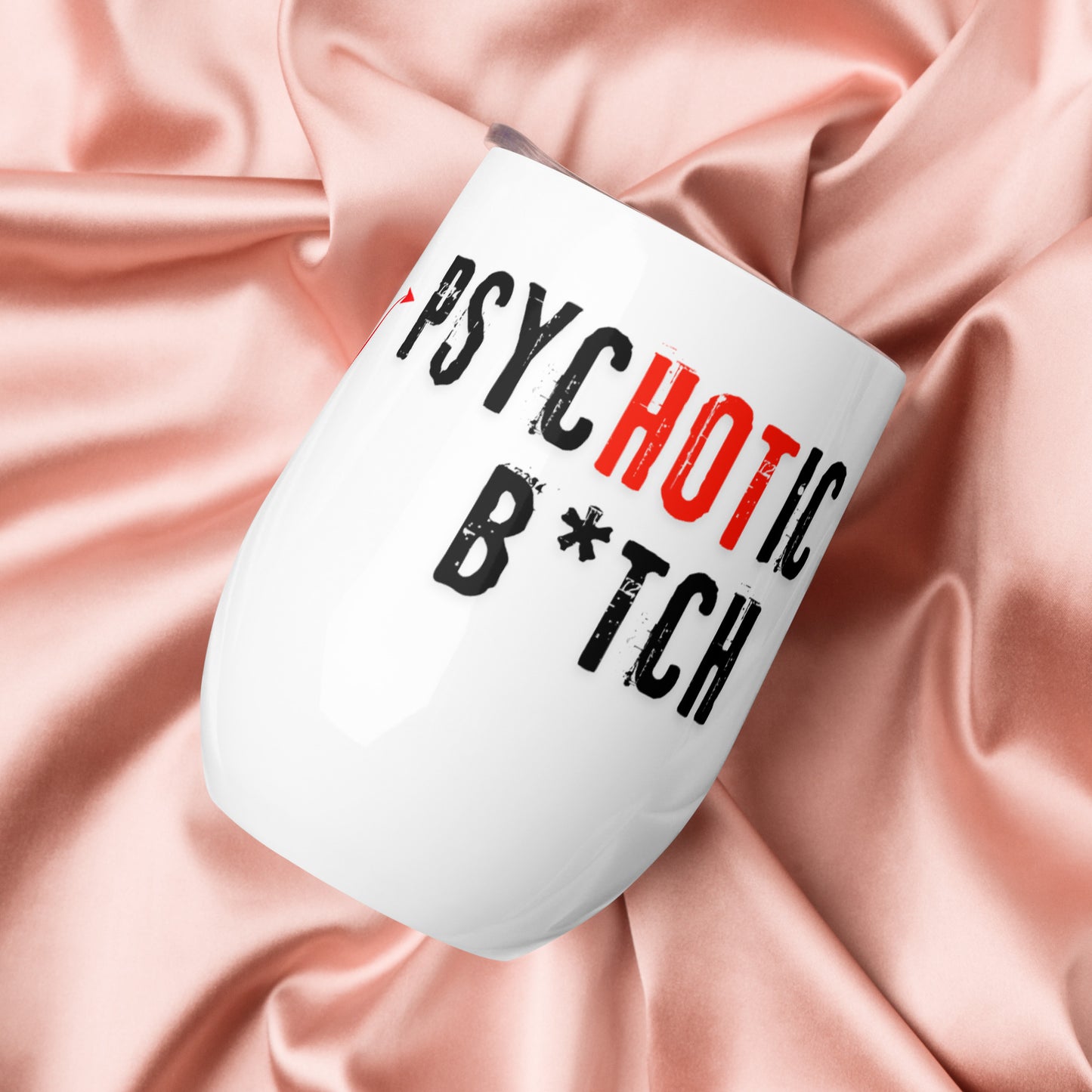 Wine tumbler with text 'I am the PsycHOTic B*tch Everyone Told You About.' Tumbler is on a silk background.